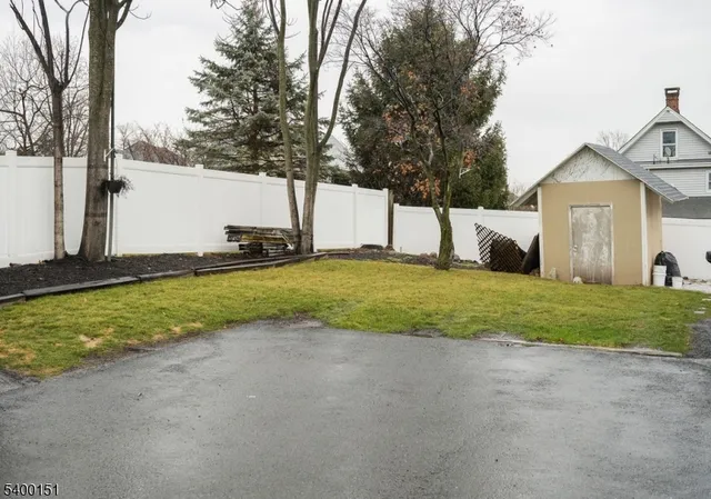 a view of a house with a big yard and large tree