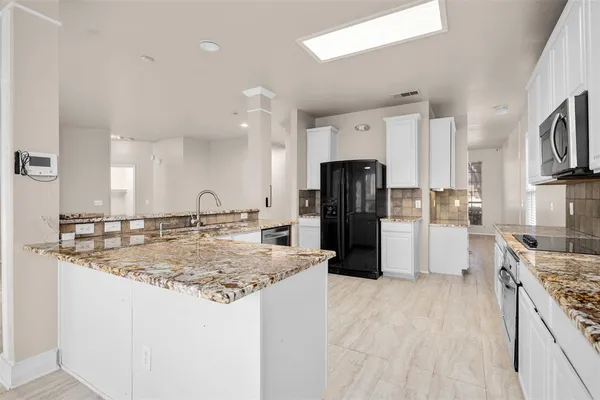a kitchen with stainless steel appliances granite countertop a sink stove and refrigerator