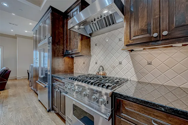 a kitchen with stainless steel appliances granite countertop a stove and a sink
