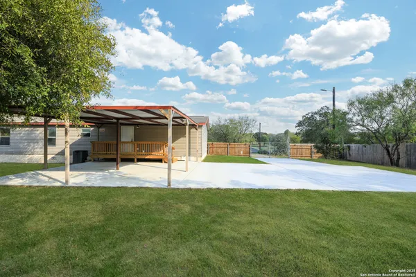 a view of a house with a big yard and a large tree