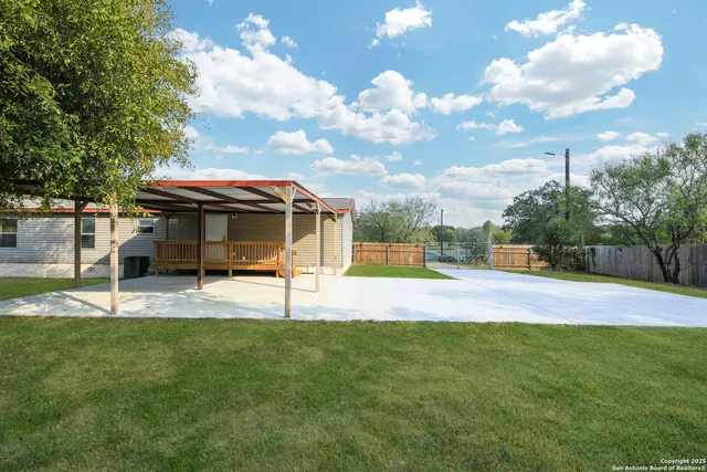 a view of a house with a big yard and a large tree