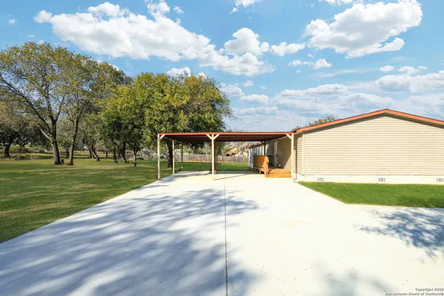 a view of a house with a big yard and a large trees