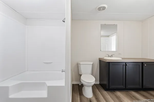 a bathroom with a sink a toilet and shower