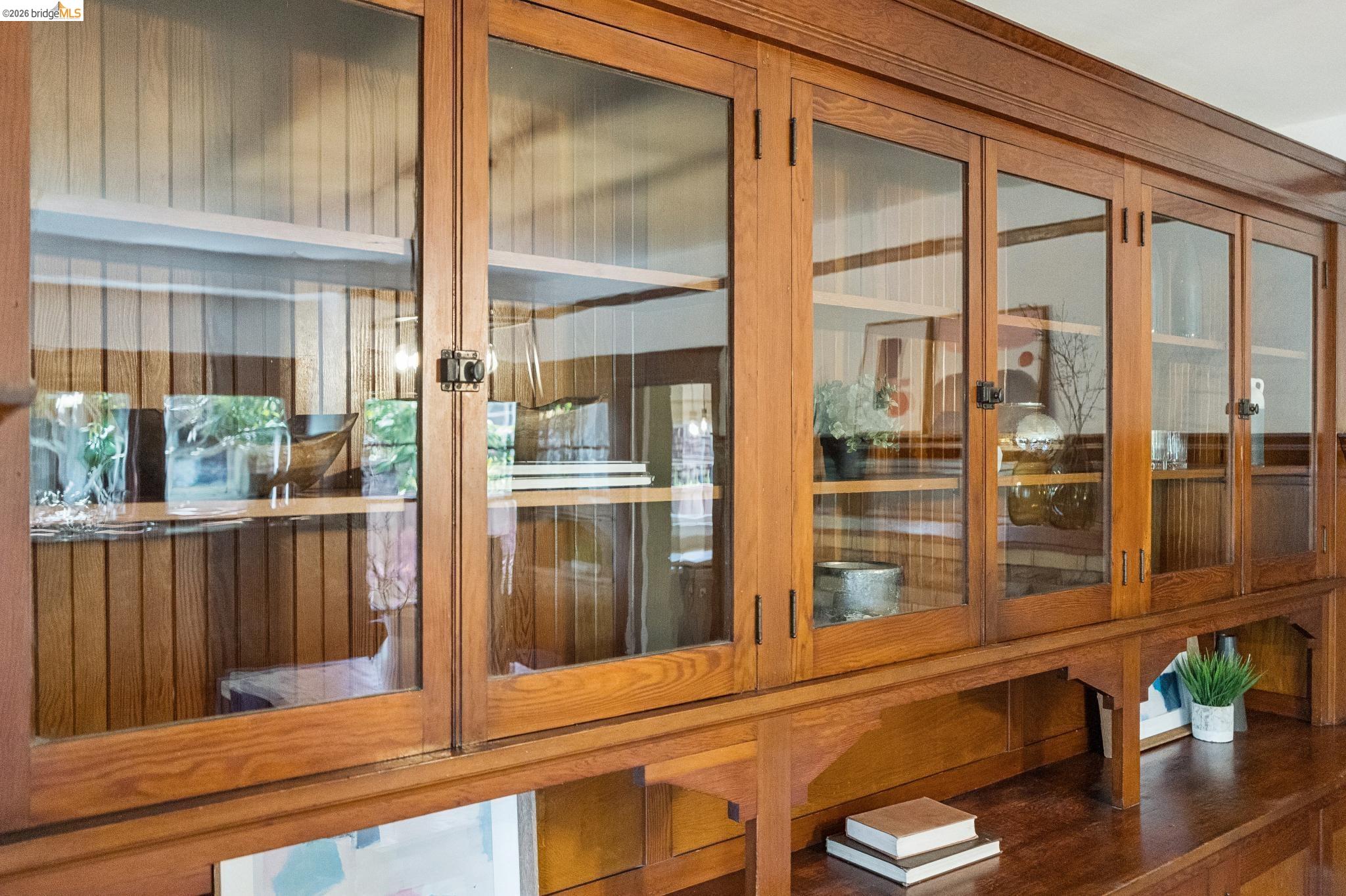1701 Derby Street Berkeley, CA 94703 - Photo 16 of 39 Built-in wood cabinetry with glass-front doors, integrated shelving, and lower open storage compartments