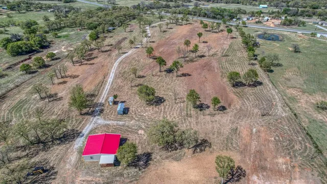 a view of dirt field and trees