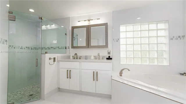 a bedroom with a bed a mirror on dresser and a chandelier