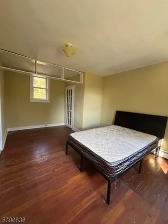 an empty room with wooden floor chandelier fan and windows