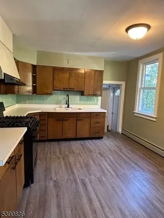 a kitchen with stainless steel appliances granite countertop a sink and a stove top oven