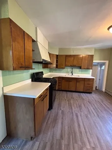 a kitchen with wooden floors and wooden cabinets