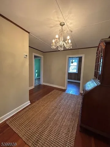 a view of a livingroom with wooden floor and chandelier