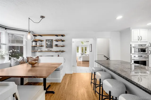 a kitchen with granite countertop a table chairs stove and cabinets