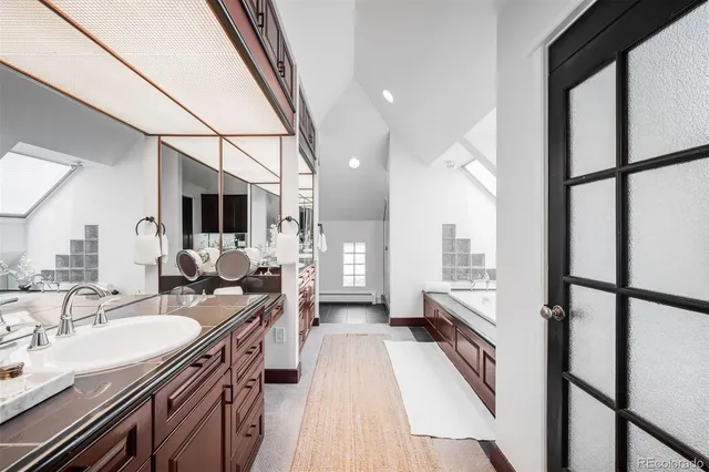 a spacious bathroom with a double vanity sink a mirror and a shower