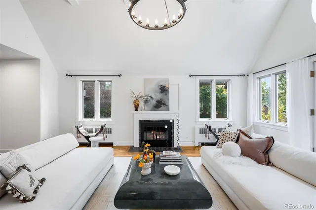 a living room with furniture a fireplace and a large window