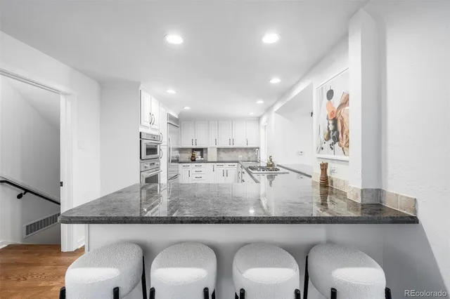 a kitchen with kitchen island granite countertop a table and chairs