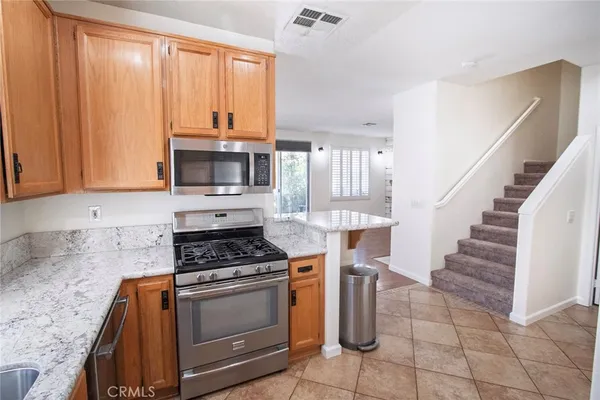 a kitchen with granite countertop a stove a sink and a microwave