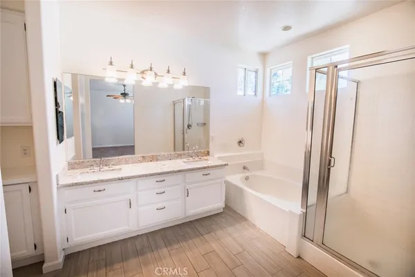 a spacious bathroom with a double vanity sink a mirror and a bathtub