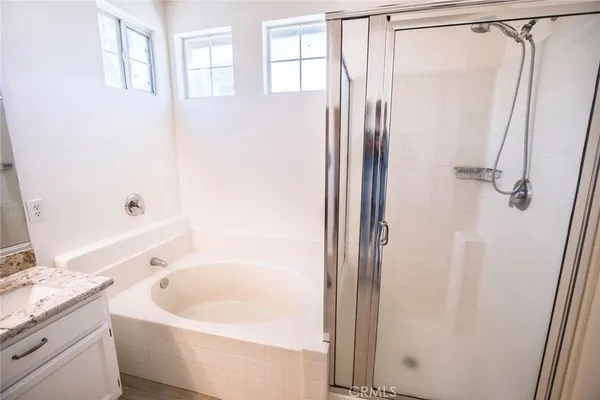 a bathroom with a tub a sink and a large mirror