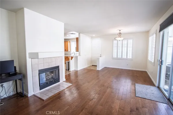 wooden floor fireplace and windows in an empty room