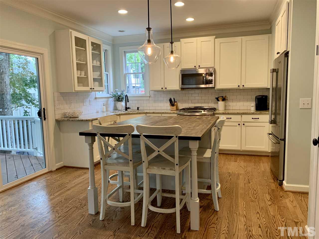 606 Scotts Ridge Trail Apex, NC 27502 - Photo 9 of 22 a kitchen with a table chairs refrigerator and microwave
