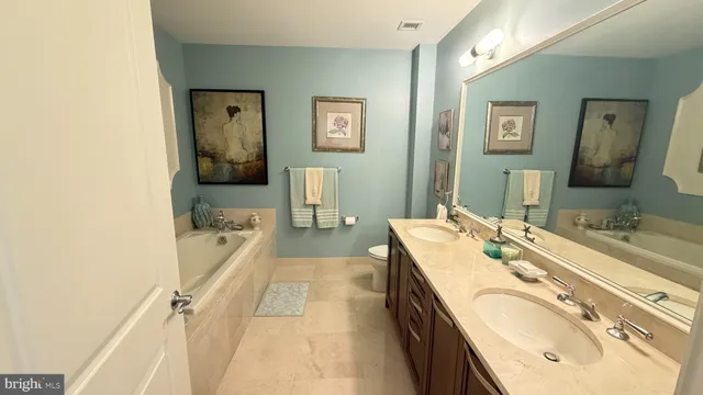 a spacious bathroom with a tub sink and mirror