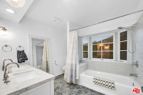 a bathroom with a tub sink and mirror