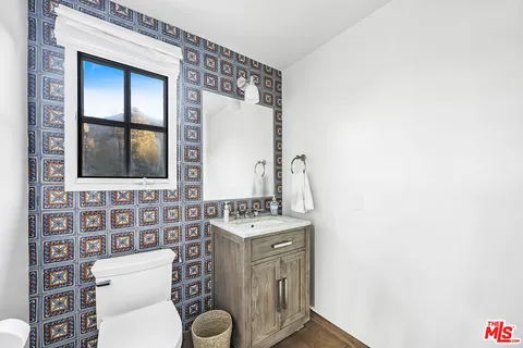 a bathroom with a toilet a sink and a mirror