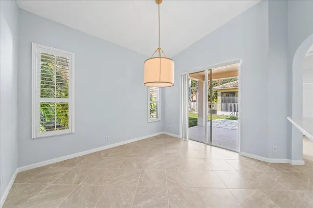en empty room with kitchen view and a window