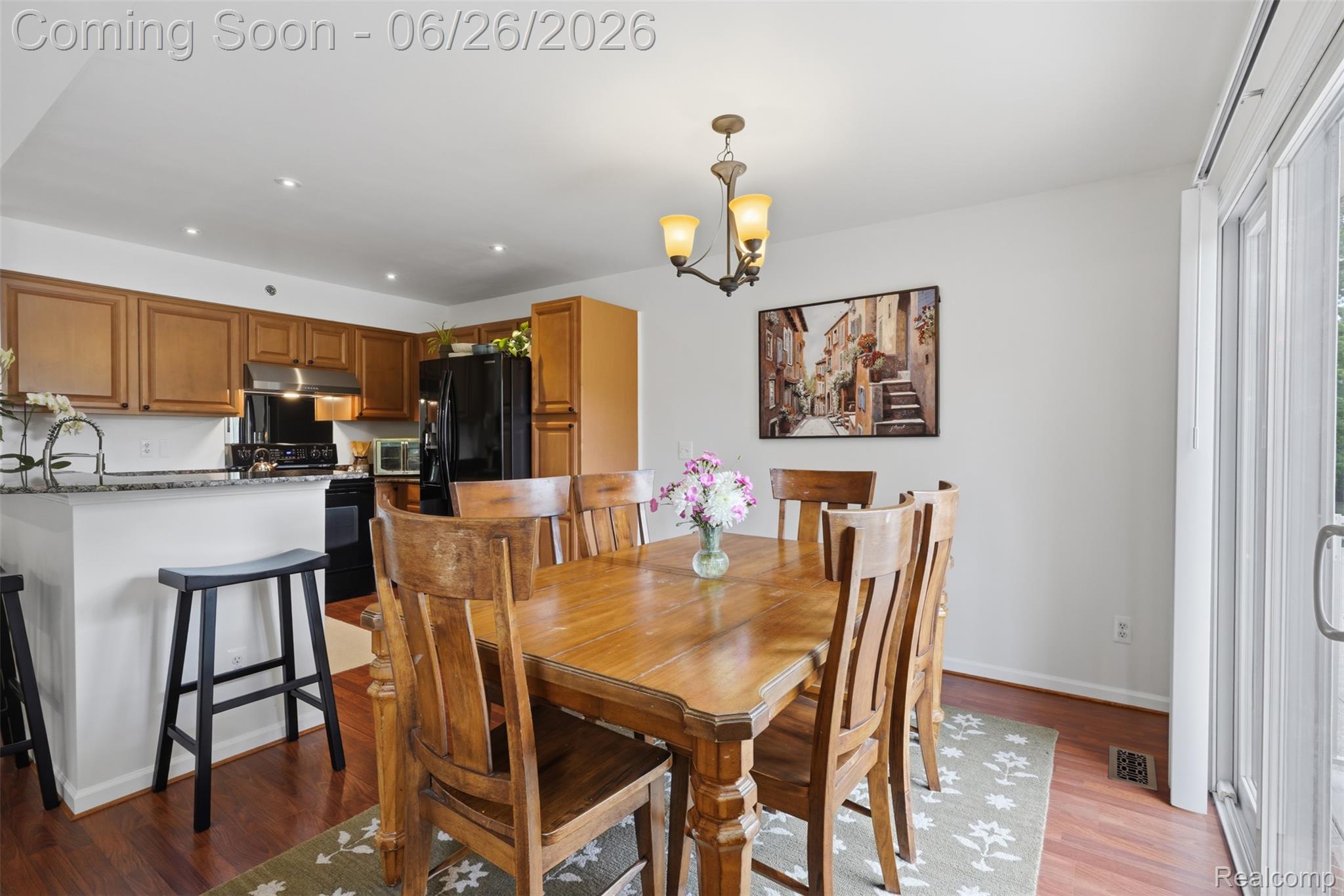 1668 Deepwood Circle Rochester, MI 48307 - Photo 12 of 27 Dining area featuring wood-finish flooring, a contemporary chandelier, and direct access to outdoor space via sliding glass doors