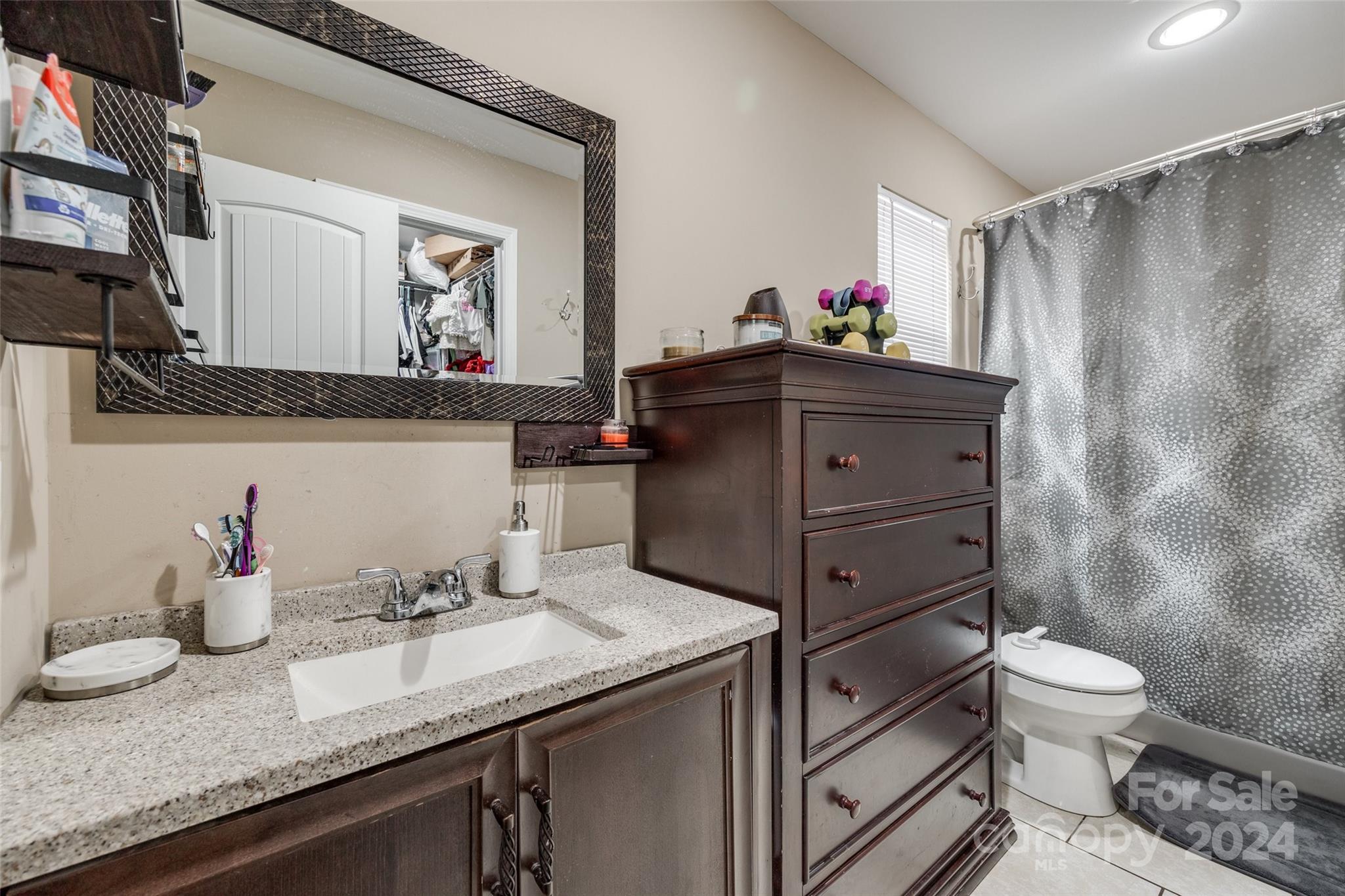 199 Cheek Road Clover, SC 29710 - Photo 16 of 27 a bathroom with a granite countertop sink vanity mirror and toilet
