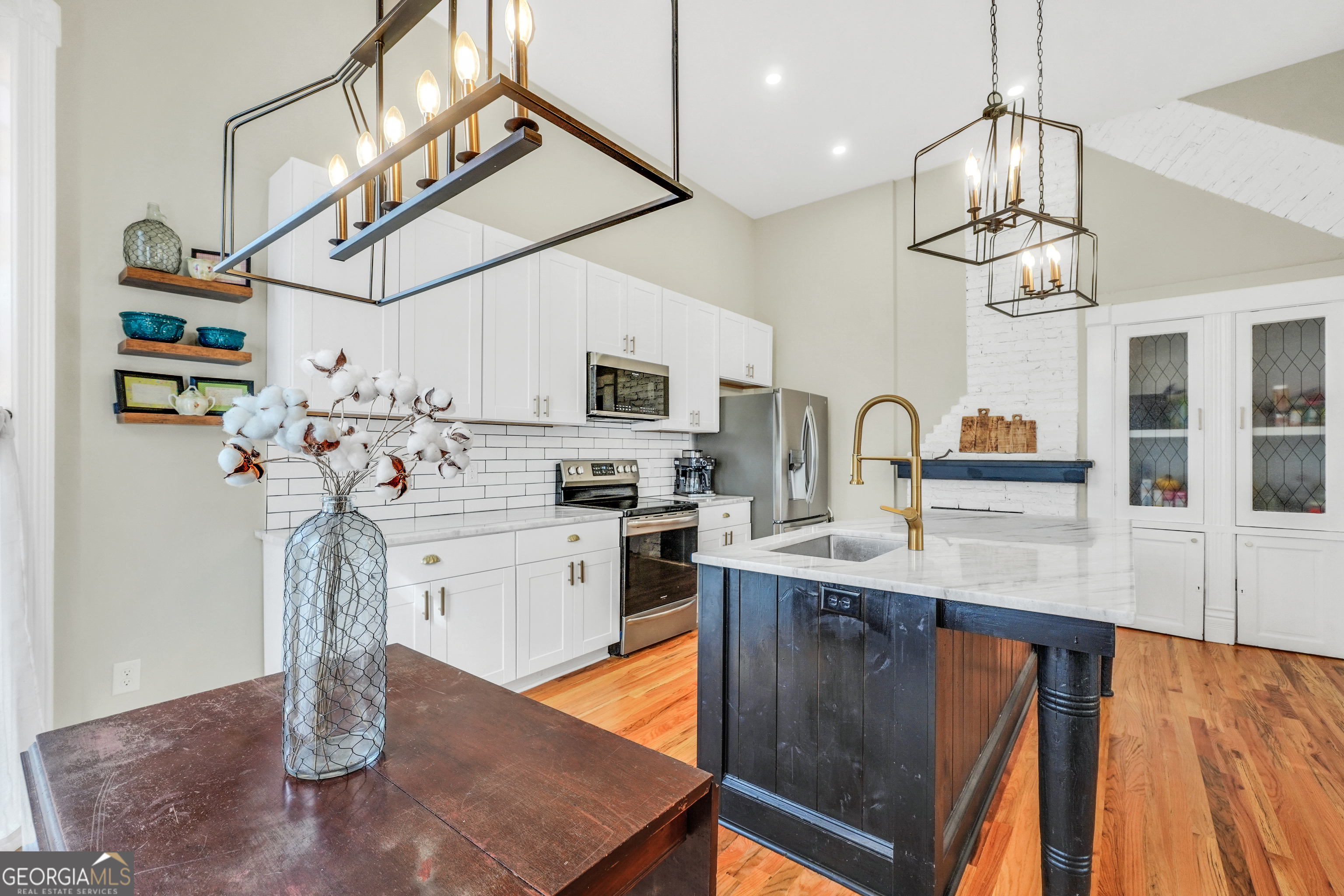 263 Julia Street Monticello, GA 31064 - Photo 16 of 48 a kitchen with stainless steel appliances granite countertop a sink dishwasher a microwave oven a stove with wooden floor and cabinets