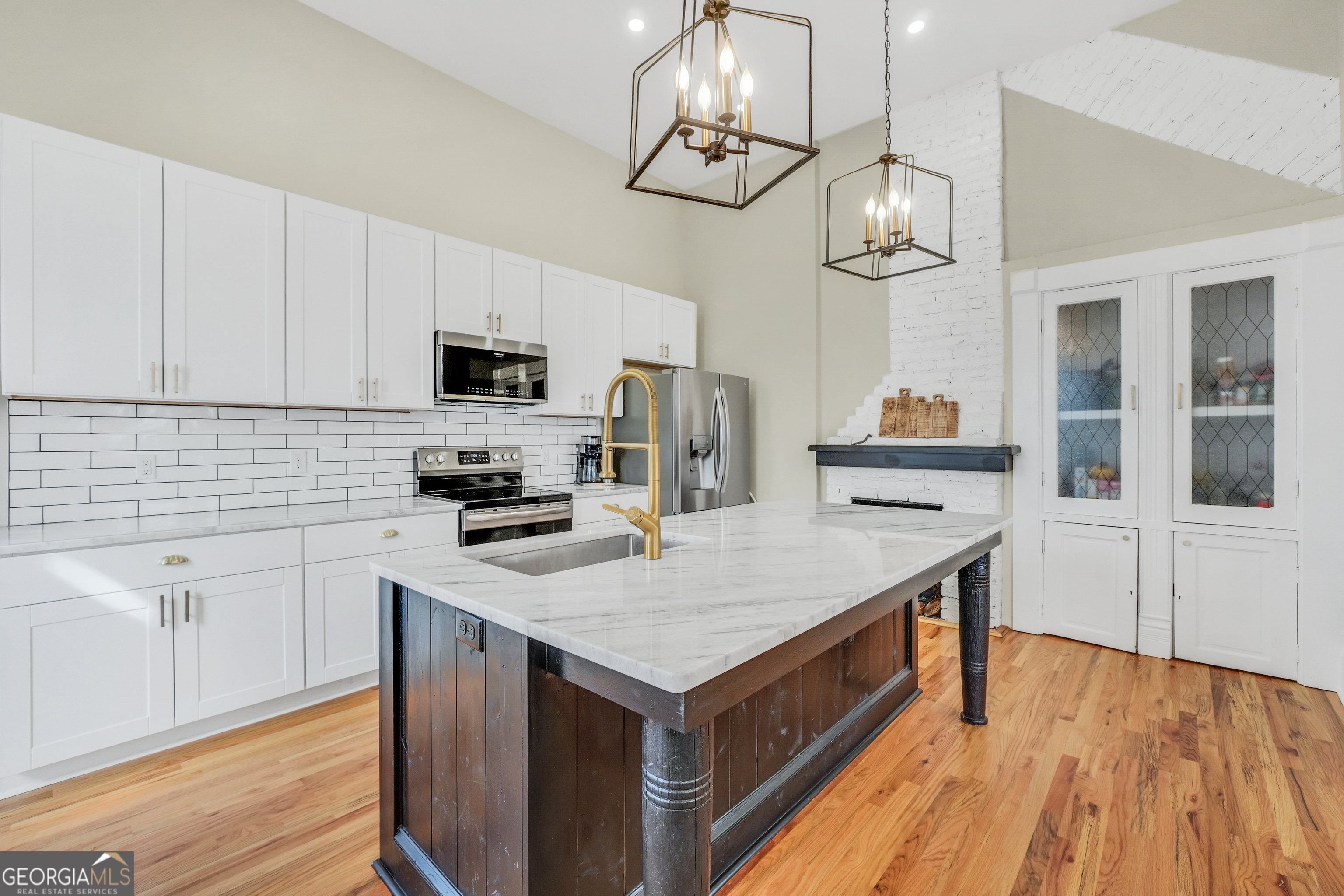 263 Julia Street Monticello, GA 31064 - Photo 9 of 48 a kitchen with a stove window and wooden floor
