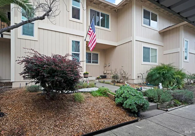 a view of a house with a yard and potted plants