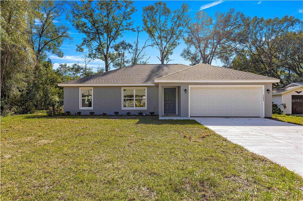 12472 Southeast 67th Terrace Road Belleview, FL 34420 - Photo 1 of 18 a front view of a house with a garden