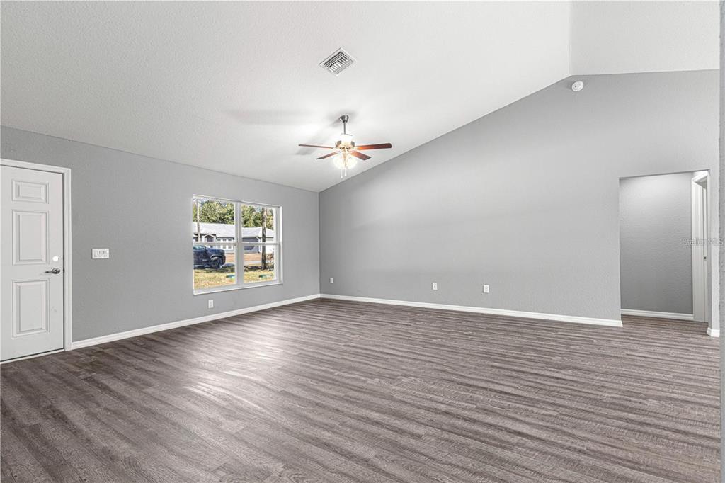12472 Southeast 67th Terrace Road Belleview, FL 34420 - Photo 17 of 18 wooden floor in an empty room with a window