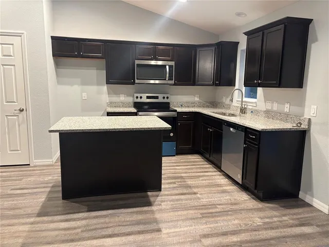 a kitchen with stainless steel appliances granite countertop a sink stove and oven