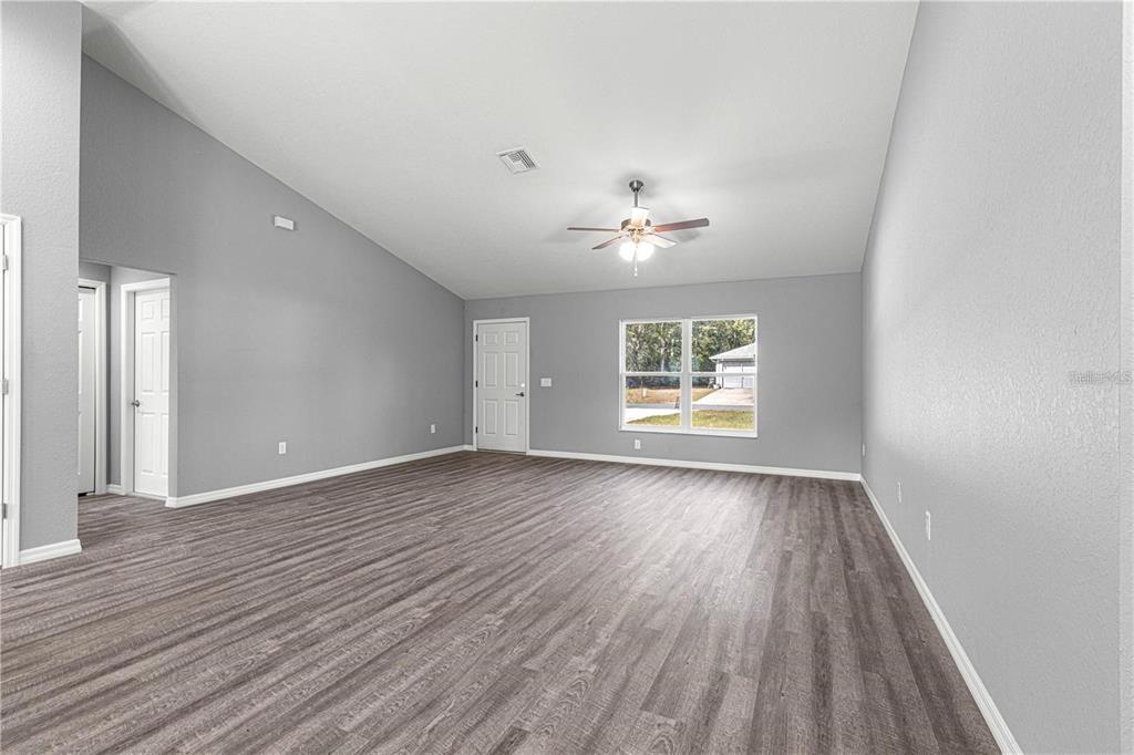 12472 Southeast 67th Terrace Road Belleview, FL 34420 - Photo 8 of 18 wooden floor in an empty room with a window