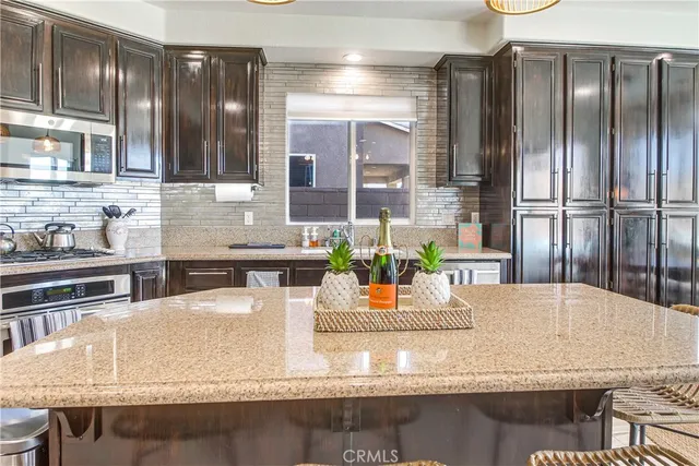a kitchen with granite countertop a sink and a refrigerator