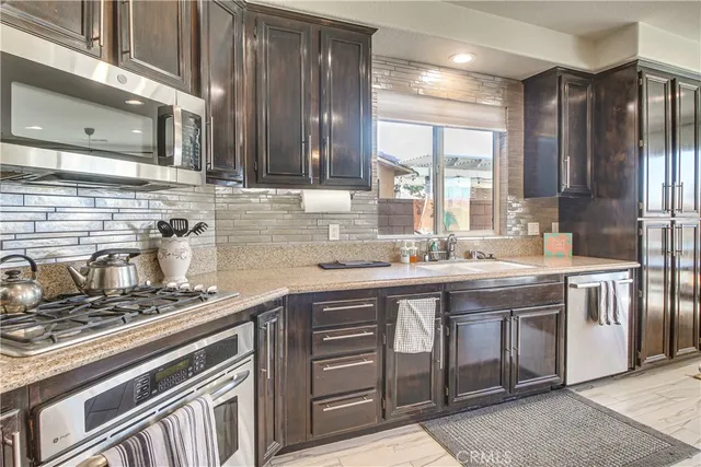a kitchen with stainless steel appliances granite countertop a sink stove and cabinets