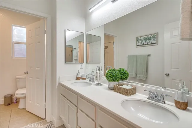 a bathroom with a double vanity sink mirror and toilet