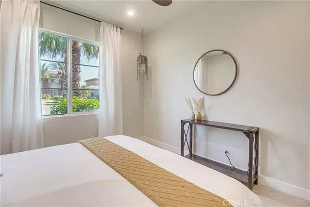 a bedroom with a bed mirror and a window