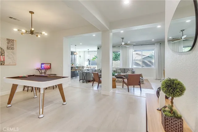 a living room with furniture a chandelier and a dining table