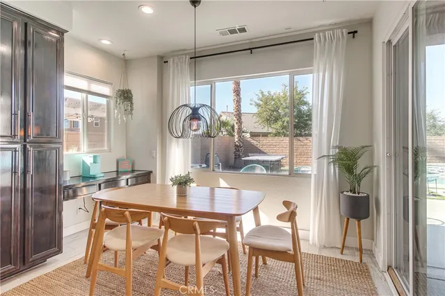 a dining room with stainless steel appliances a dining table chairs and chandelier