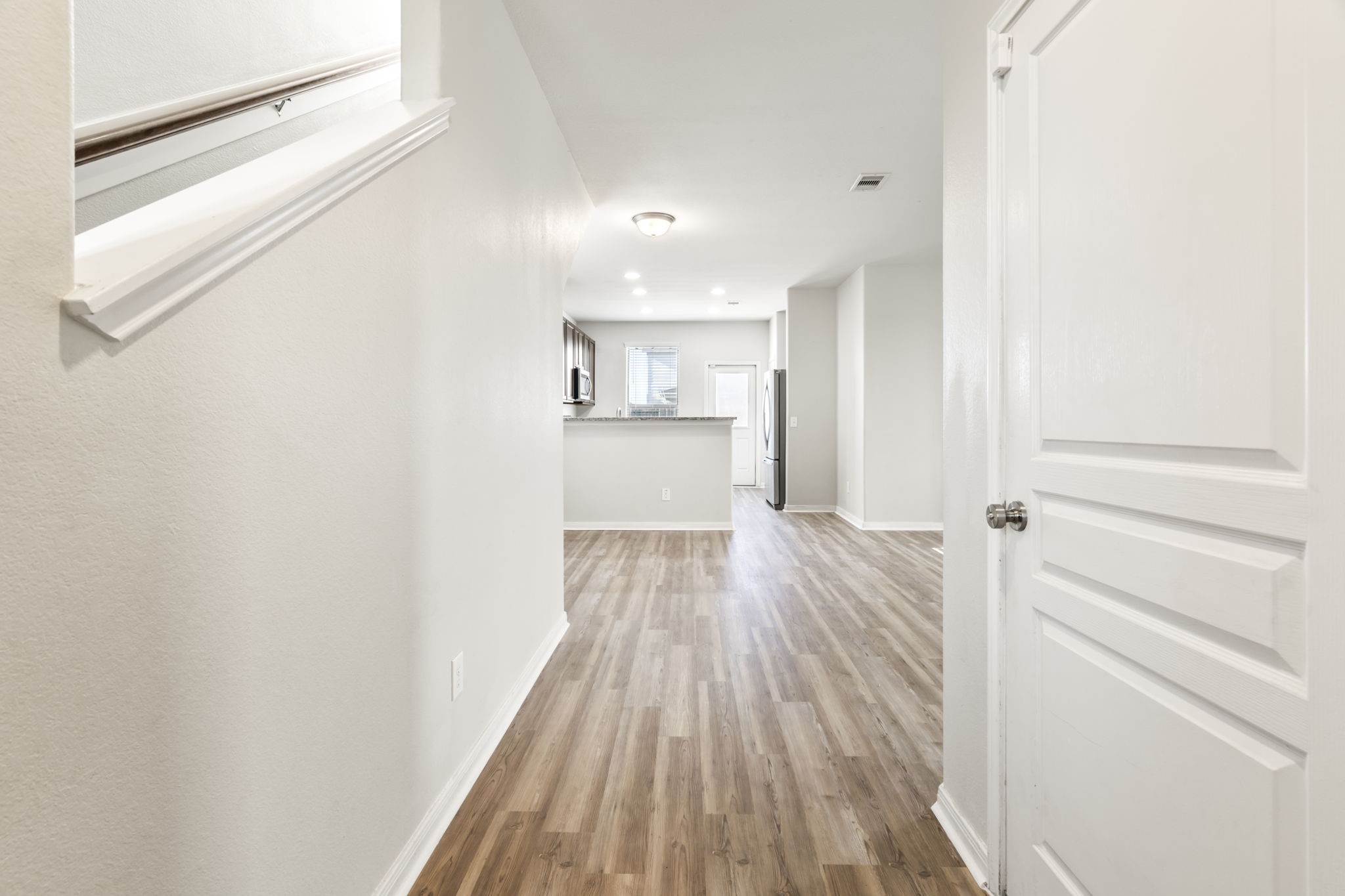 914 Canyon Hill Lane Rosenberg, TX 77471 - Photo 29 of 31 a view of a hallway with wooden floor and a kitchen