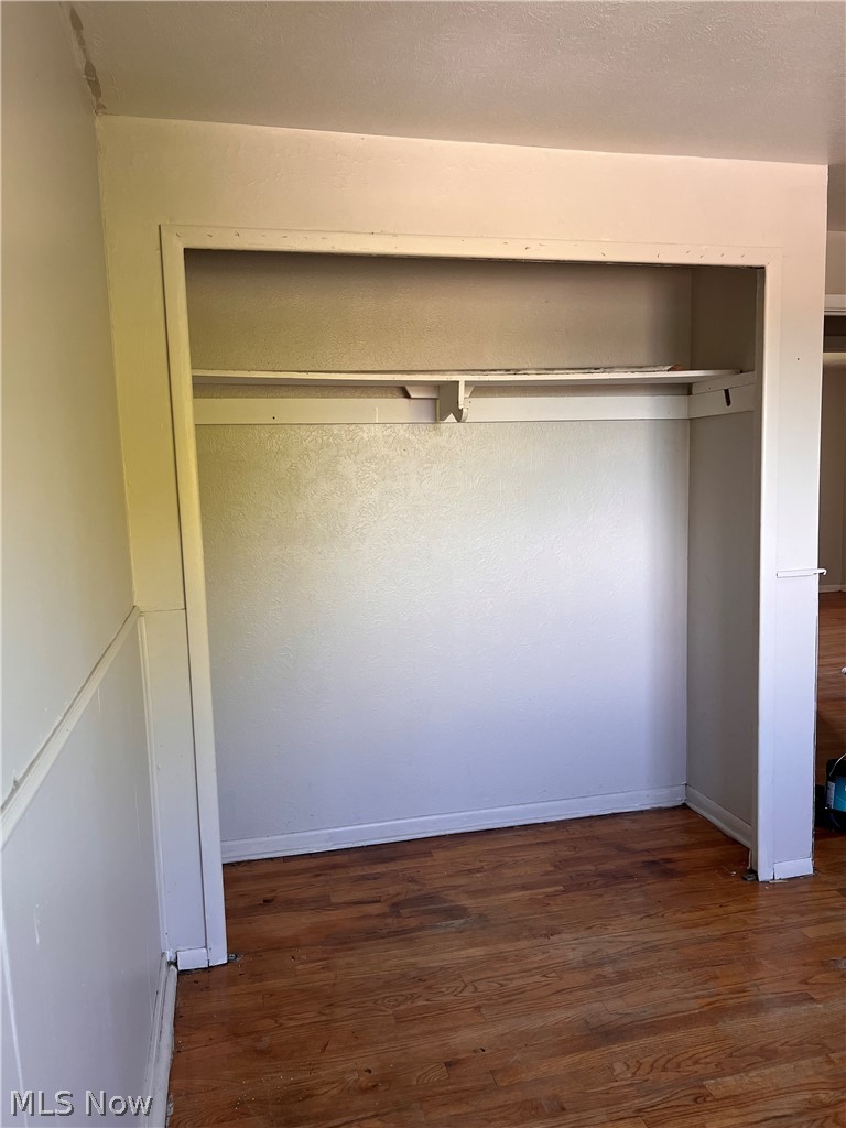 16350 Rockside Road Maple Heights, OH 44137 - Photo 20 of 34 Recessed closet with a single shelf and hanging rod, featuring wood-finish flooring and white baseboards