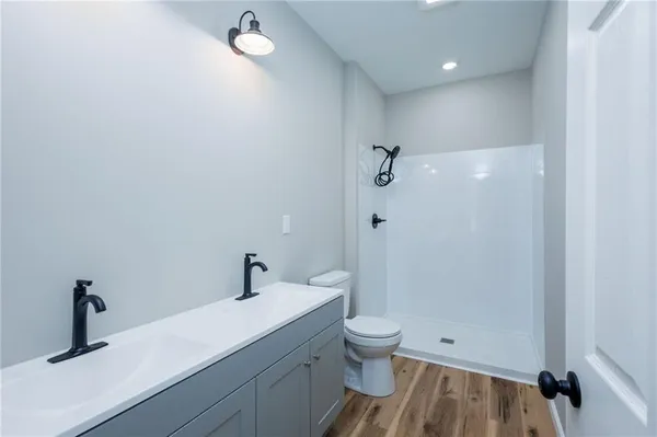 a bathroom with a sink a toilet and shower
