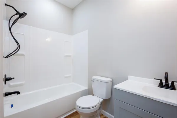 a white toilet sitting next to a bath tub