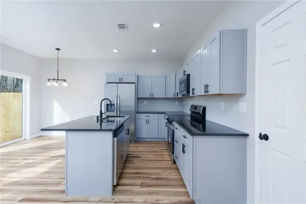 a kitchen with stainless steel appliances granite countertop a sink stove and refrigerator