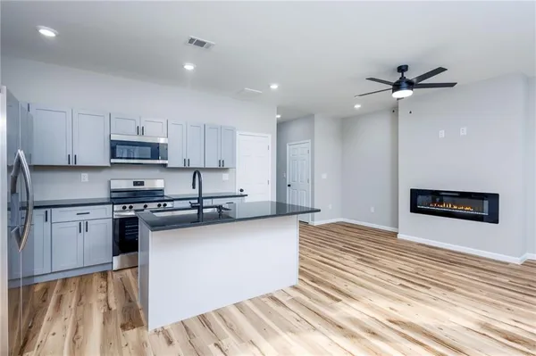 a kitchen with stainless steel appliances granite countertop a stove a sink and a refrigerator