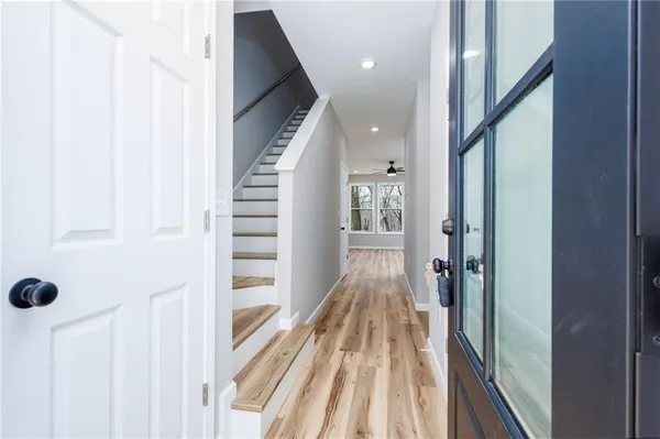 a view of a hallway with wooden floor and staircase