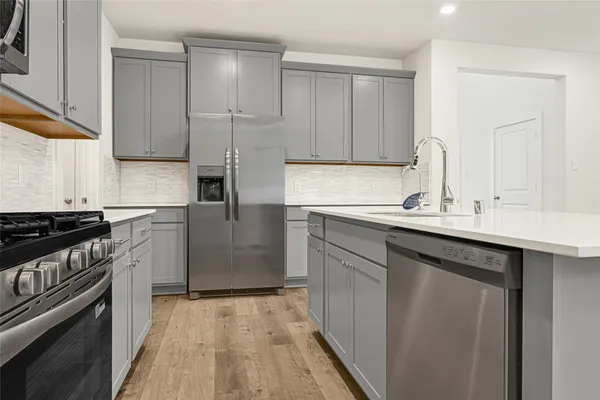 a kitchen with a sink stove and cabinets